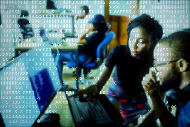 Instructor guiding students working at a computer screen
