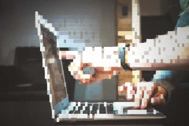 Hands collaborating over a laptop keyboard