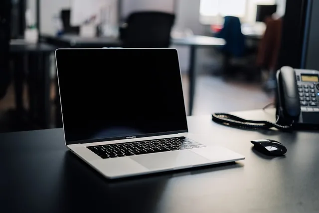 Laptop and desk phone on an office desk